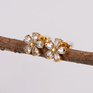 Elegant gold stainless steel flower stud earrings with sparkling crystals on wood branch