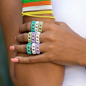 Close-up of colorful chain-link resin rings and bracelets worn on model hand