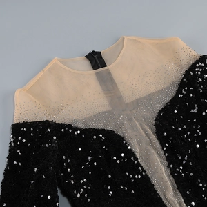 Detail of black sequin dress featuring sheer mesh neckline and silver rhinestone accents