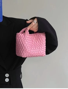 Close-up of pink woven leather texture on a mini bucket bag with a stylish handle