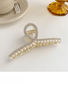 Détail de la pince à cheveux dorée champagne avec perles blanches et strass étincelants