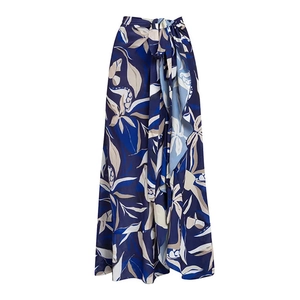 Detail of high-waisted wrap skirt with blue botanical print and ruffled hemline