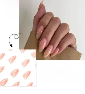 Detail view of pink press-on nails with golden French tip lines and nude finish
