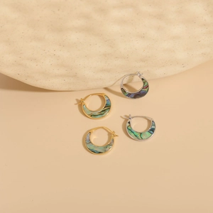 Dettaglio di orecchini a mezzaluna in oro e argento con inserto in conchiglia iridescente