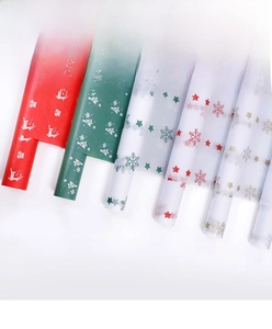 Rolls of Christmas wrapping paper with festive reindeer and snowflake patterns