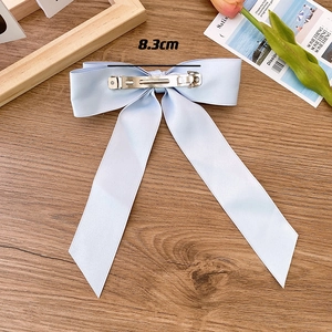 Detail of light blue satin bow hair clip showing the 8.3cm metal spring clip mechanism