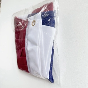 Folded US pleated fan flag showing stars stripes and metal grommets in polybag