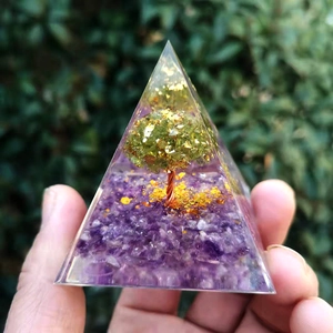 Close-up of Orgone pyramid with amethyst base and copper wire tree encased in clear resin