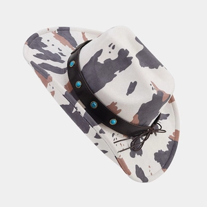Detail of cow print western cowboy hat with turquoise beaded band and side bow accent