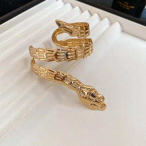 Close-up of golden snake bracelet featuring detailed scales and multi-layered spiral design