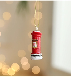 Close-up of a resin red British mailbox ornament with faux snow and heart detail