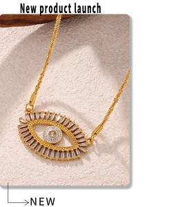Macro detail of Evil Eye pendant with sparkling baguette zircons on gold-plated necklace