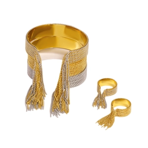 Two-tone woven metal jewelry set featuring a wide cuff bracelet and rings with long tassels