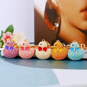 Detailed macro view of five colorful pearl duck keychains with sparkling rhinestone bows