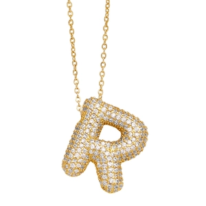 Macro shot of gold bubble letter R pendant necklace with white cubic zirconia stones