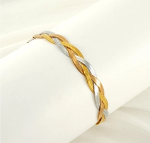 Close-up of two-tone braided snake chain bracelet on a white display stand