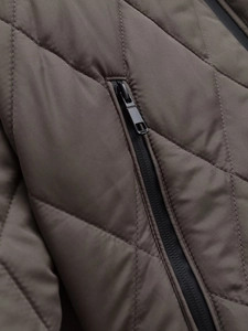 Close-up of diamond quilting and matte black zipper pocket on brown puffer coat