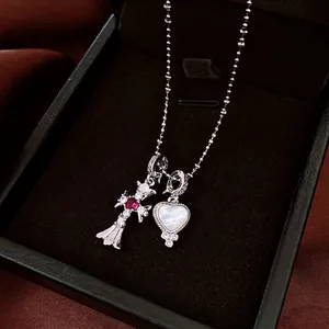 Zircon cross and shell heart pendant necklace with red gemstone on silver bead chain