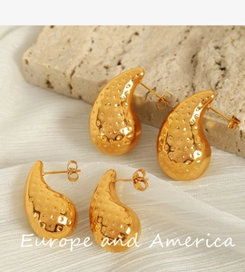 Macro shot of 18K gold-plated teardrop earrings with hammered texture and butterfly back