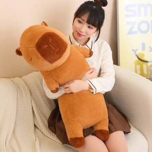 Close-up of soft brown capybara plush pillow with detailed embroidery and sleeping expression