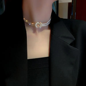 Elegantes zweilagiges Perlen- und Strass-Choker mit Knotendesign auf schwarzem Blazer