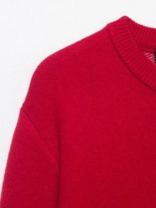 Dettaglio del maglione rosso a maglia con particolare su colletto a coste e spalla
