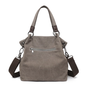 Gray canvas tote bag with brown leather straps and back zipper pocket, front view
