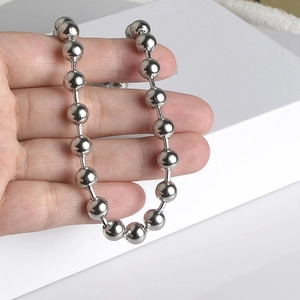 Hand holding silver stainless steel ball bead chain necklace for personalized DIY jewelry
