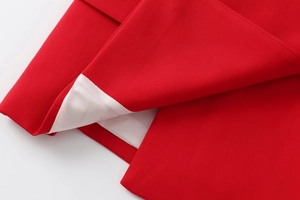 Detailed close-up of red fabric texture and white lining stitches for women suits