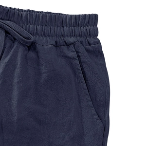 Detailed view of dark blue linen shorts featuring drawstring elastic waist and side pockets