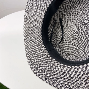 Detail view of woven straw hat interior featuring black sweatband and adjustable drawstring