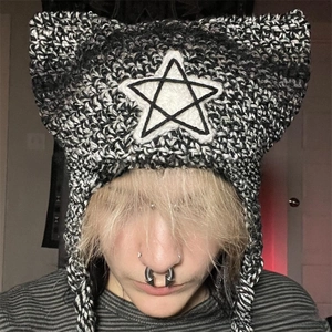 Close-up of knit cat ear beanie featuring a white star patch and long tassel ties