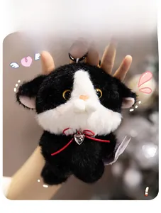 Close-up of fluffy black and white cat plush keychain with red bow and heart pendant