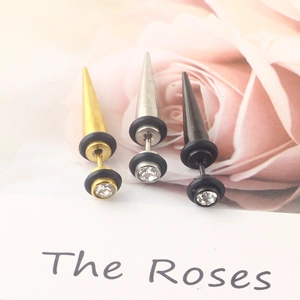 Detailed macro view of three cone stud earrings in gold, silver, and black with rhinestones