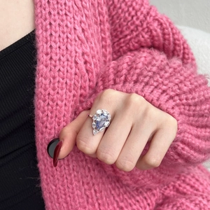 Detailed view of S925 sterling silver ring with large pear-cut blue gemstone on finger