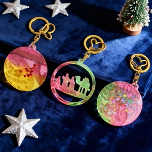 Detalle de colgante navideño de resina con silueta y llavero con forma de corazón metálico