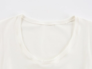 Detailed close-up of a white U-neckline on a soft cotton knitted t-shirt with neat stitching