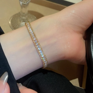 Macro detail of gold-plated double-row rhinestone bracelet with sparkling zircons