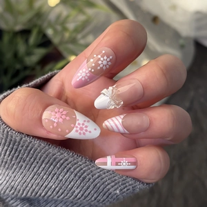 3D press on nails with almond shape, festive snowflakes and 3D bow on pink French tips