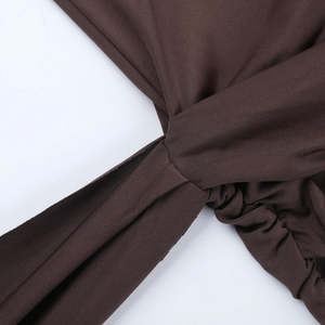Detail of dark brown ribbed knit dress featuring ruched drawstring and tie-up design