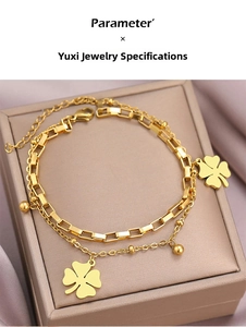 Detail of double-layer stainless steel gold bracelet with four-leaf clover charms