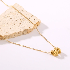 Minimalist 18K gold plated necklace with interlocking oval rings on a stone display