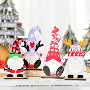 Close-up of four festive wooden Christmas gnomes with Welcome and Merry Christmas signs
