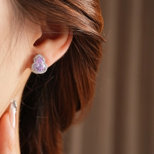 Close-up of elegant pink gourd earrings with sparkling zircons on a model's ear