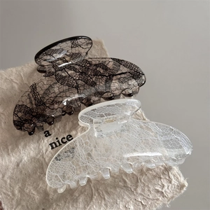 Detail of medium lace pattern hair claw clips in black and white with metal springs