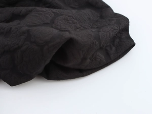Nahaufnahme der schwarzen Jacquard-Stoffstruktur mit 3D-Blumenmustern auf dem Kleid