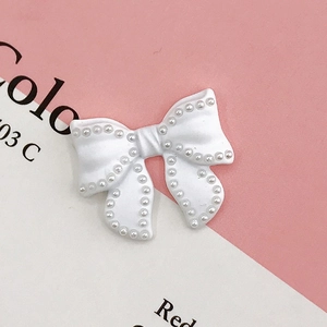 Detailed close-up of white resin bow with pearl trim for DIY phone case accessories
