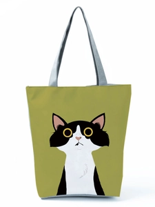 Close-up of olive green canvas tote bag with a cute black and white cartoon cat print