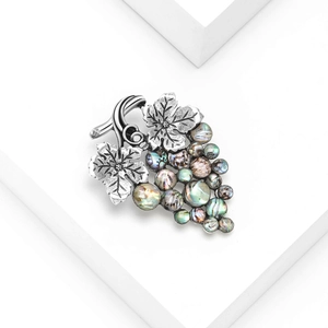 Vintage silver grape brooch with iridescent abalone shell inlay on white background