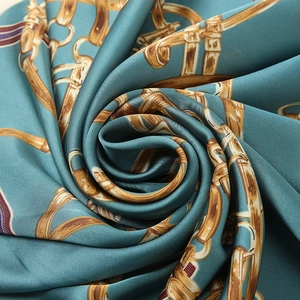 Macro detail of silk scarf showing glossy texture and vintage gold chain print